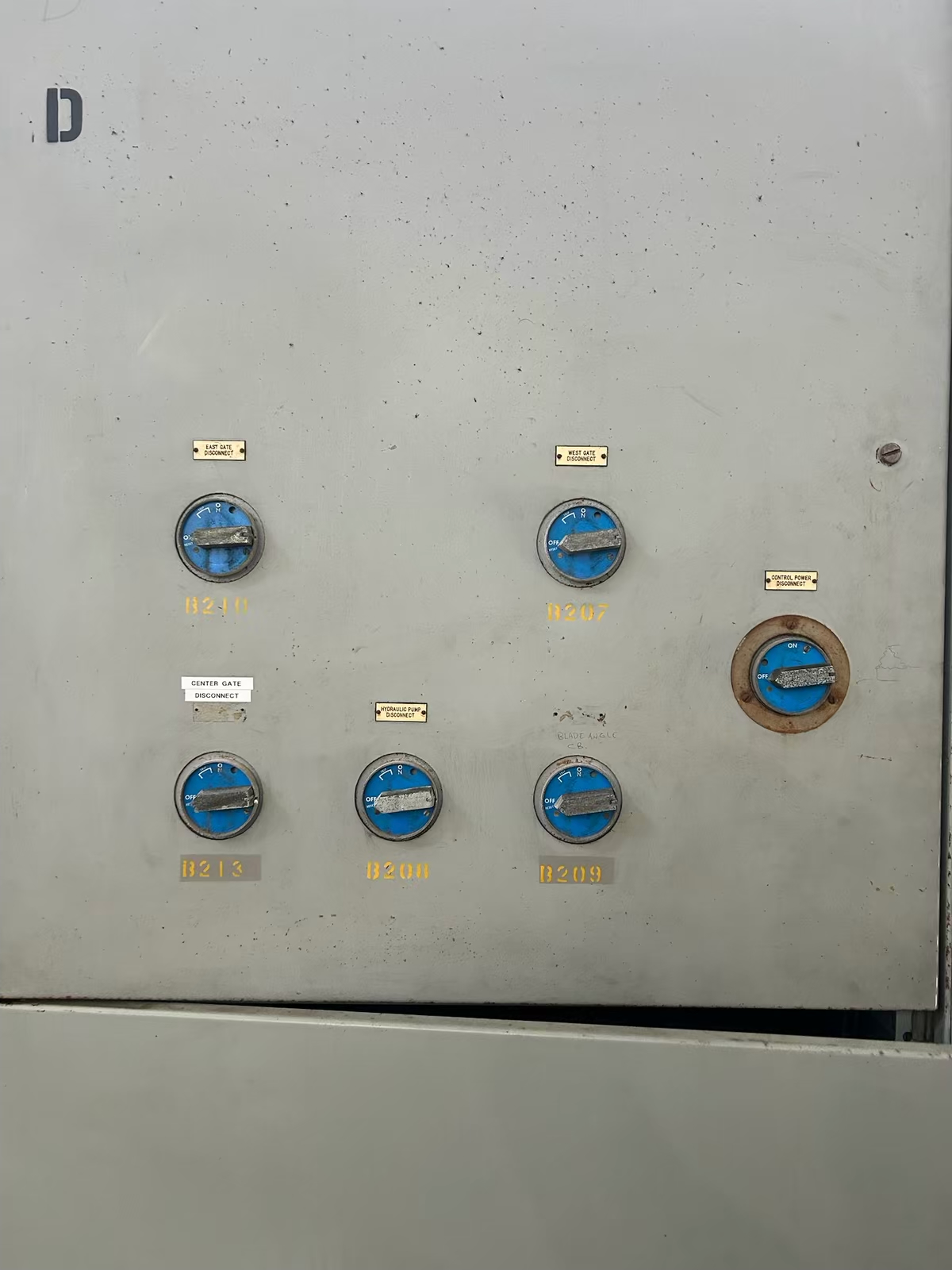 Row of blue rotary disconnect switches on a control cabinet
